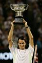 <p>Federer with the trophy after victory in his Men’s Singles Final match against Marcos Baghdatis on January 29, 2006 </p>