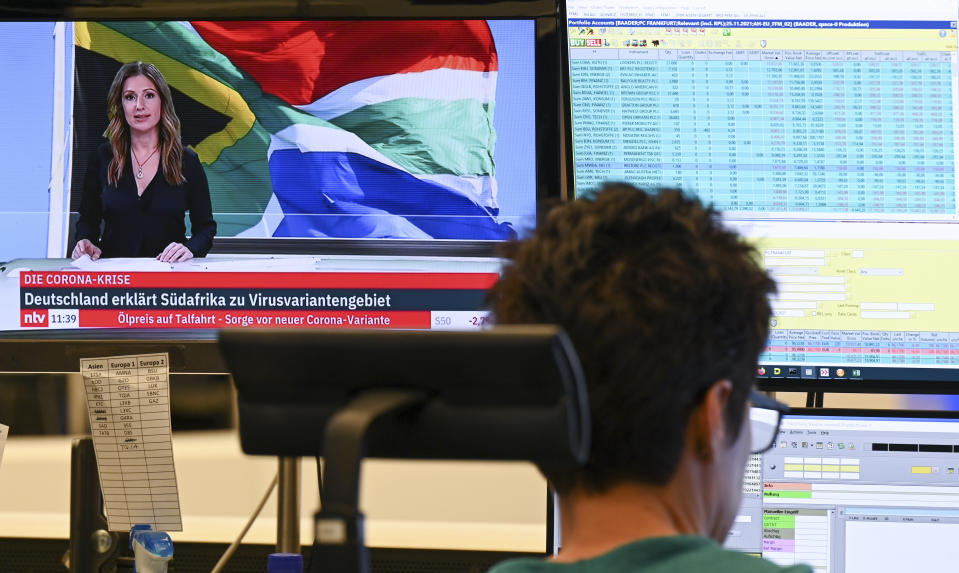 A stock trader looks at his monitors in the trading room of the Frankfurt Stock Exchange in Frankfurt, Germany, Friday, Nov. 26, 2021. A news about a new coronavirus mutation in southern Africa have dealt a heavy blow to the German stock market. (Arne Dedert/dpa via AP)