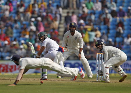 South Africa's Faf du Plessis (2nd L) plays a shot as India's captain Virat Kohli dives to catch the ball as India's Murali Vijay (2nd R) and wicketkeeper Wriddhiman Saha watch during the third day of their third test cricket match in Nagpur, November 27, 2015. REUTERS/Amit Dave