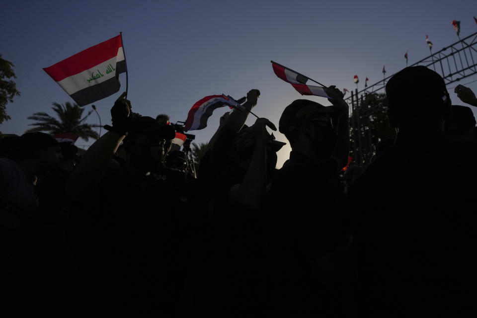 Protesters wave national flags during a protest outside the to the fortified Green Zone where the Danish embassy is, located in Baghdad, Iraq, Saturday, July 22, 2023, following reports of the burning of a Quran carried out by a ultranationalist group in front of the Iraqi Embassy in Copenhagen. (AP Photo/Hadi Mizban)