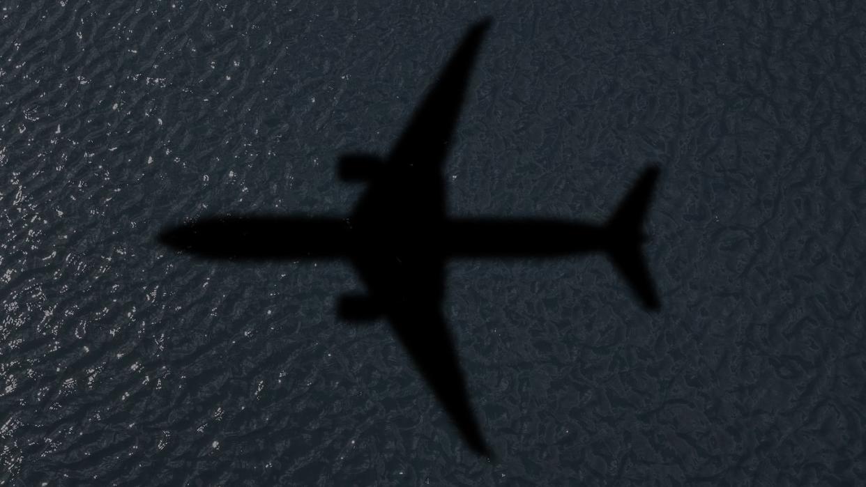 water reflection of dark water with the shadow of an airplane