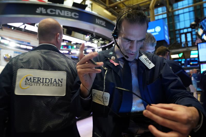 FILE PHOTO: Traders work at the New York Stock Exchange