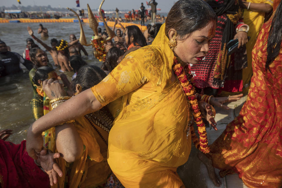 In this Jan. 15, 2019, photo, members of the newly formed "'Kinnar akhara" take a dip on the auspicious Makar Sankranti day during the Kumbh Mela festival in Prayagraj, Uttar Pradesh state, India. This is the first time the newly formed monastic order, led by transgender activist Laxmi Narayan Tripathi, has set up camp at the massive temporary city in Prayagraj. Unlike other akharas, which are only open to Hindu men, Kinnar, founded in 2015, is open to all genders and religions. (AP Photo/Bernat Armangue)