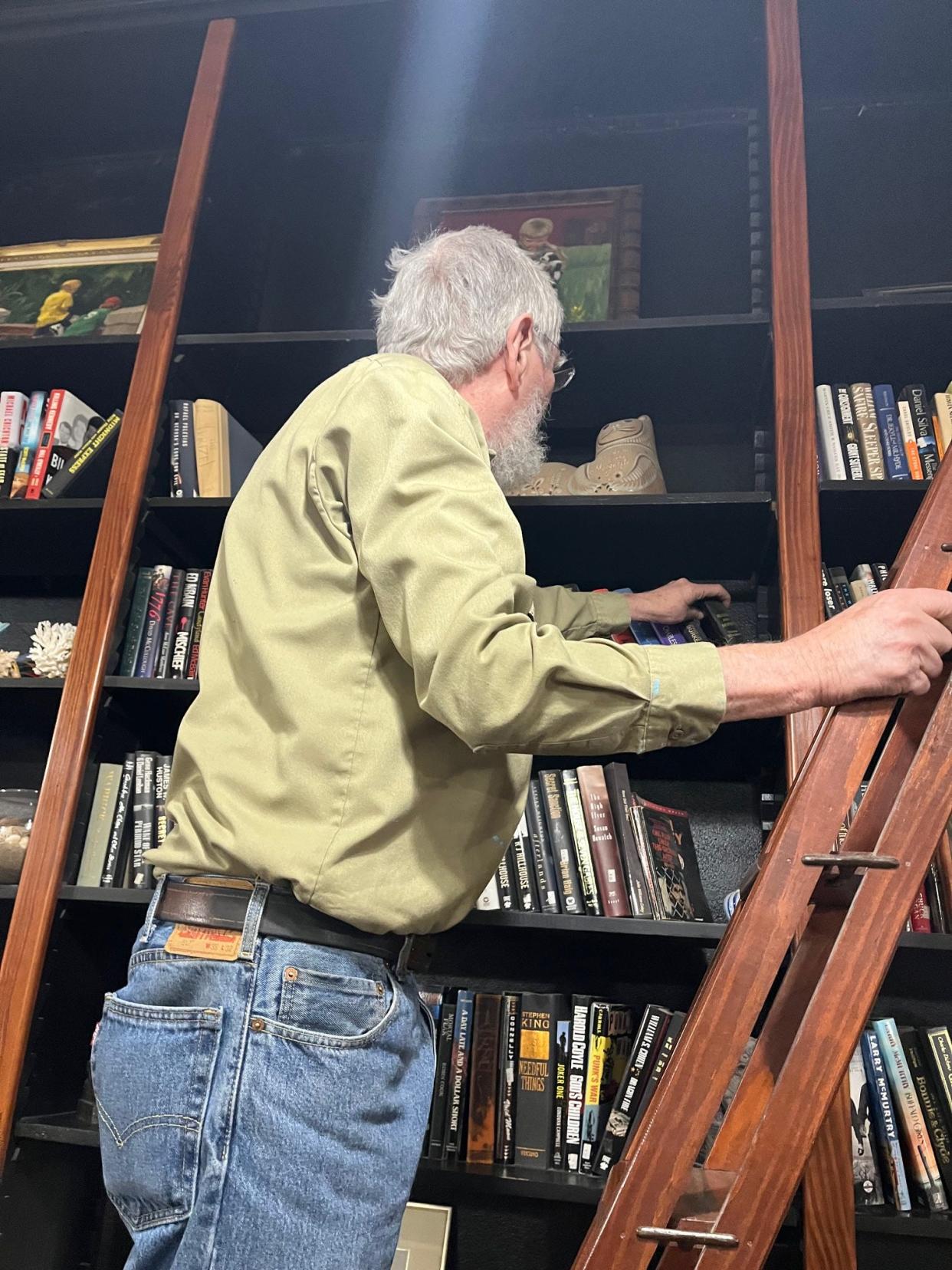 Mike Morford converted merchandise shelves into bookshelves in the former stationery business he turned into a home. He restored the ladder once used by clerks to fetch merchandi