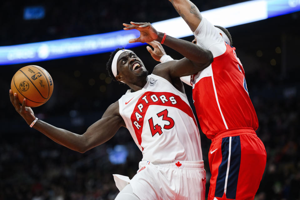 Pascal Siakam (43), de los Raptors de Toronto, ataca la canasta con la marca defensiva de Daniel Gafford, derecha, de los Wizards de Washington, durante la segunda mitad del juego de baloncesto de la NBA, en Toronto, el lunes 13 de noviembre de 2023. (Christopher Katsarov/The Canadian Press vía AP)