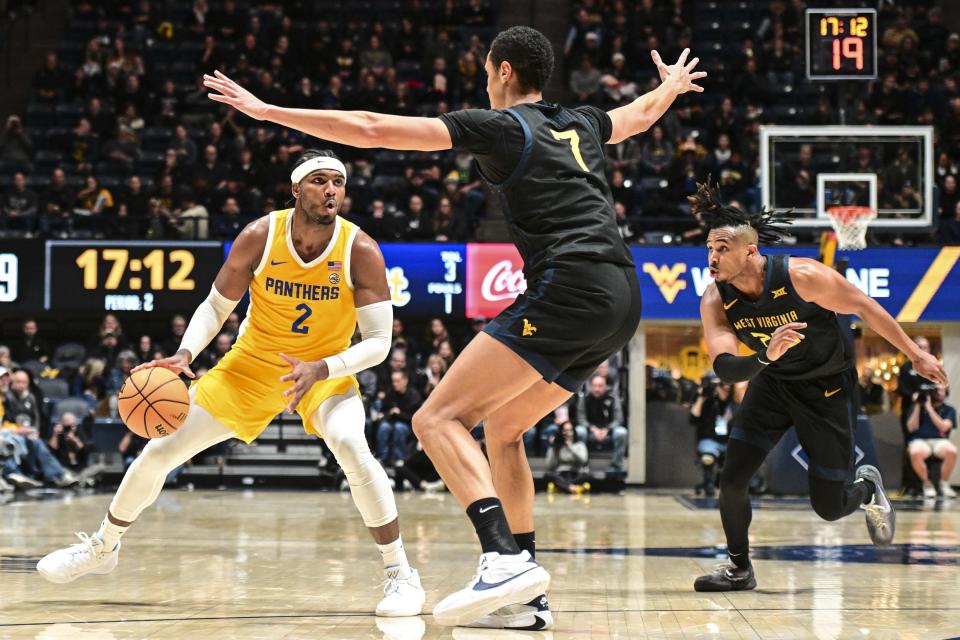 Pittsburgh forward Blake Hinson (2) protects the ball from West Virginia center Jesse Edwards (7) during the second half of an NCAA college basketball game Wednesday, Dec. 6, 2023, in Morgantown, W.Va. (William Wotring/The Dominion-Post via AP)