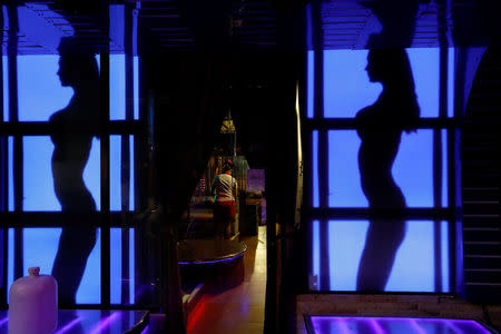 A woman stands inside a go-go bar before they open for customers in Pattaya, Thailand March 25, 2017. REUTERS/Jorge Silva