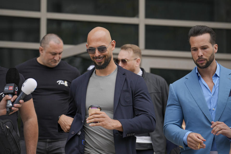 Andrew Tate, center, and his brother Tristan leave the Bucharest Tribunal in Bucharest, Romania, Wednesday, May 8, 2024. A court in Romania's capital ruled on April 26, that a trial could start but did not set a date for the trial to begin in the case of influencer Andrew Tate, who is charged with human trafficking, rape and forming a criminal gang to sexually exploit women. (AP Photo/Vadim Ghirda)