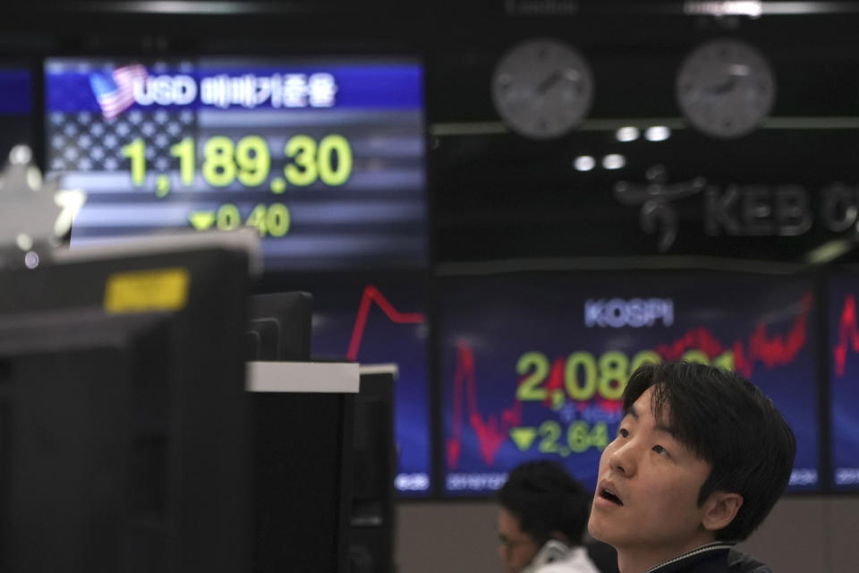 A currency trader watches computer monitors near the screens showing the Korea Composite Stock Price Index (KOSPI), right, and the foreign exchange rate between U.S. dollar and South Korean won at the foreign exchange dealing room in Seoul, South Korea, Tuesday, Dec. 10, 2019. Asian stock markets have fallen as investors look ahead to interest rate decisions by U.S. and European central bankers and possible American tariff hike on Chinese imports. (AP Photo/Lee Jin-man)