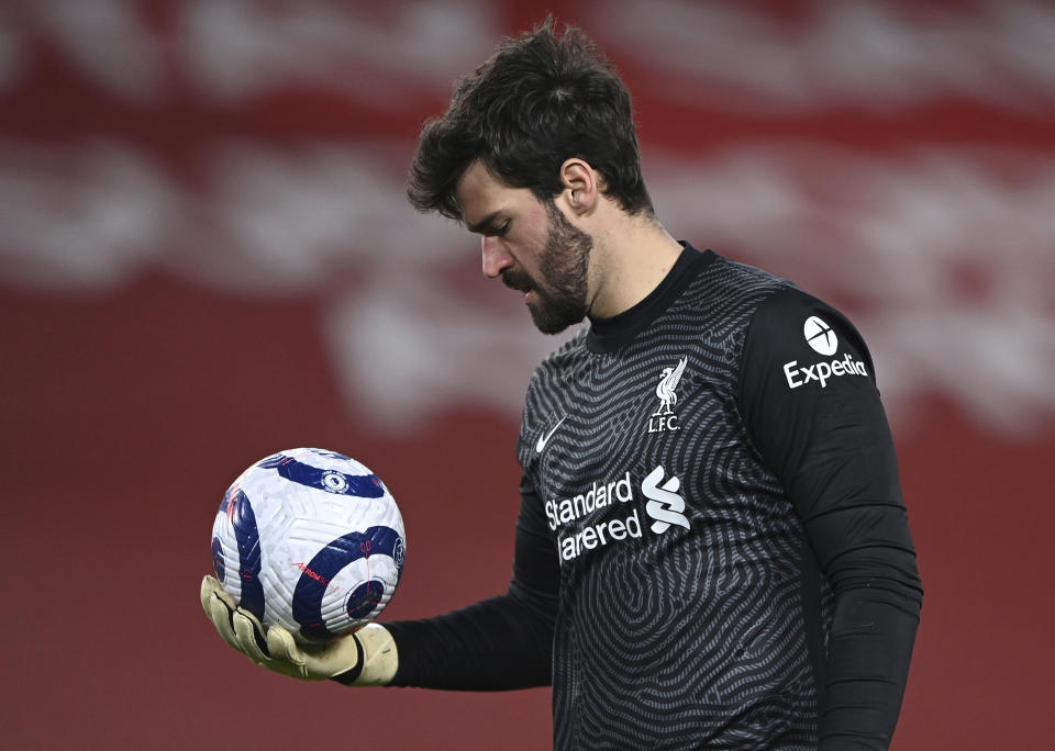 Liverpool's goalkeeper Alisson looks down at the ball during the English Premier League soccer match between Liverpool and Everton at Anfield in Liverpool, England, Saturday, Feb. 20, 2021. Everton won the game 2-0. (Lawrence Griffiths/ Pool via AP)