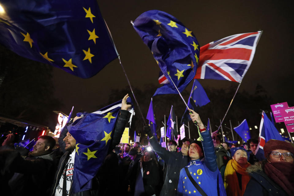 Anti-Brexit demonstrators react after the results of the vote on British Prime Minister Theresa May's Brexit deal were announced in Parliament square in London, Tuesday, Jan. 15, 2019. British lawmakers have rejected Prime Minister Theresa May's Brexit deal by a huge margin, plunging U.K. politics into crisis 10 weeks before the country is due to leave the European Union. The House of Commons voted 432 -202 on Tuesday against the deal struck between Britain's government and the EU in November. (AP Photo/Frank Augstein)