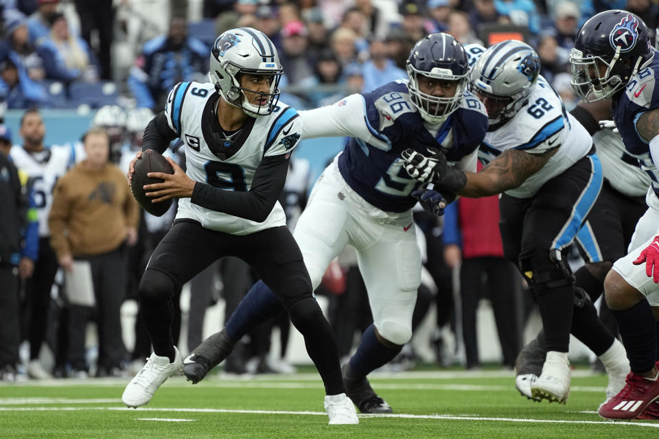 Carolina Panthers quarterback Bryce Young (9) scrambles away from Tennessee Titans defensive end Denico Autry (96) during the first half of an NFL football game Sunday, Nov. 26, 2023, in Nashville, Tenn. (AP Photo/George Walker IV)