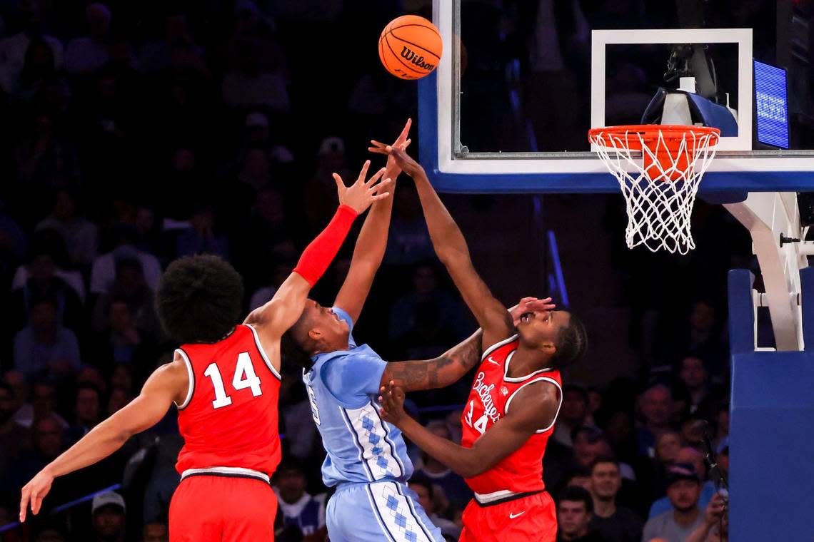 Ohio State forward Justice Sueing (14), center Felix Okpara (34) and North Carolina forward Armando Bacotrise up for the ball during the first half of an NCAA college basketball game in the CBS Sports Classic, Saturday, Dec. 17, 2022, in New York. (AP Photo/Julia Nikhinson)
