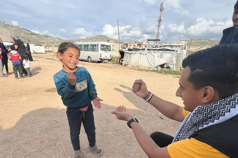 Playing rock, paper, scissors with a child at the refugee camp