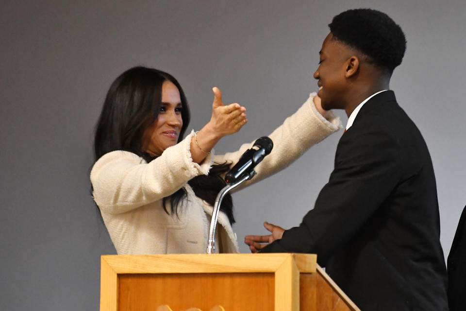 The Duchess of Sussex (left) embraces head boy Aker Okoye, in a school assembly, during her surprise visit to the Robert Clack Upper School in Dagenham, Essex, to celebrate International Women's Day.