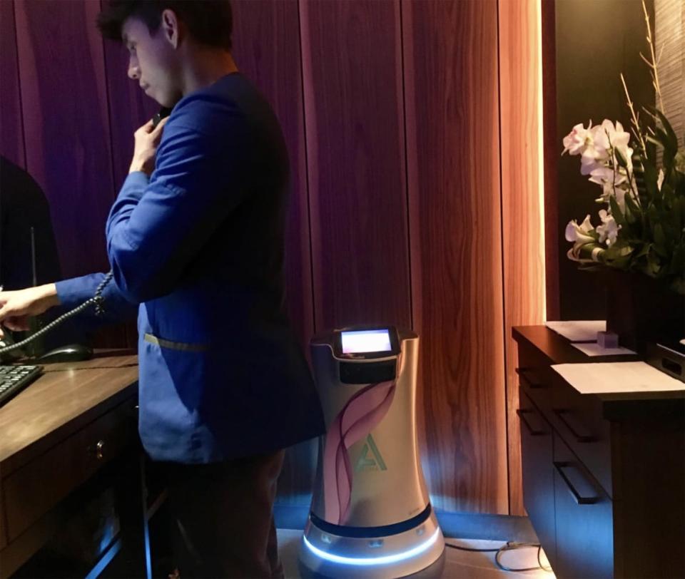 <div class="inline-image__caption"><p><em>Alina, robotic butler, stands behind the human concierge at his desk at the Times Square Luma Hotel. </em></p></div> <div class="inline-image__credit">Shira Feder for The Daily Beast</div>