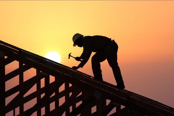 A carpenter working on a house frame.