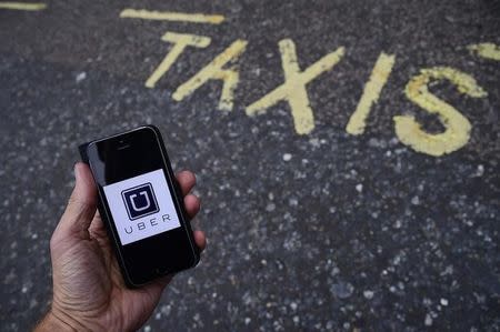 A photo illustration shows the Uber app logo displayed on a mobile telephone, as it is held up for a posed photograph in central London, Britain October 28, 2016. REUTERS/Toby Melville/Illustration
