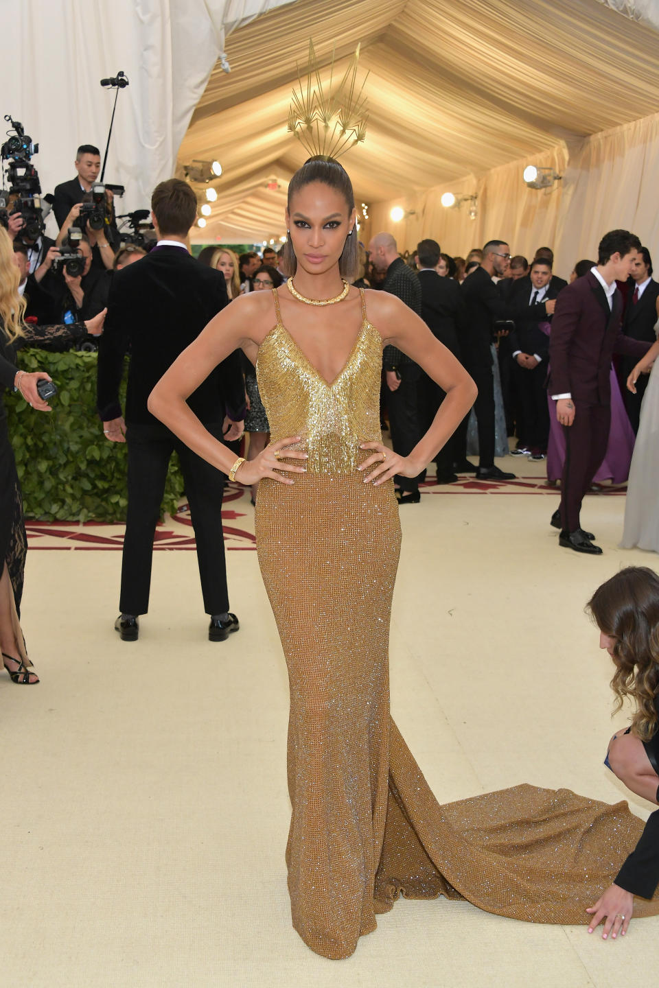 <p>Dressed to perfection in a gold Tommy Hilfiger plunging gown, Joan Smalls even had a helper to fix her train on the red carpet. Photo: Getty Images </p>