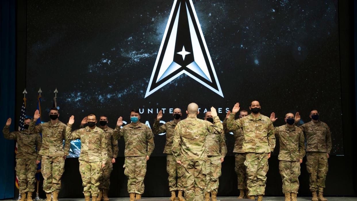  military personnel in uniform raise their right hands to take the oath of office officially transferring from the United State Air Force to the United States Space Force 