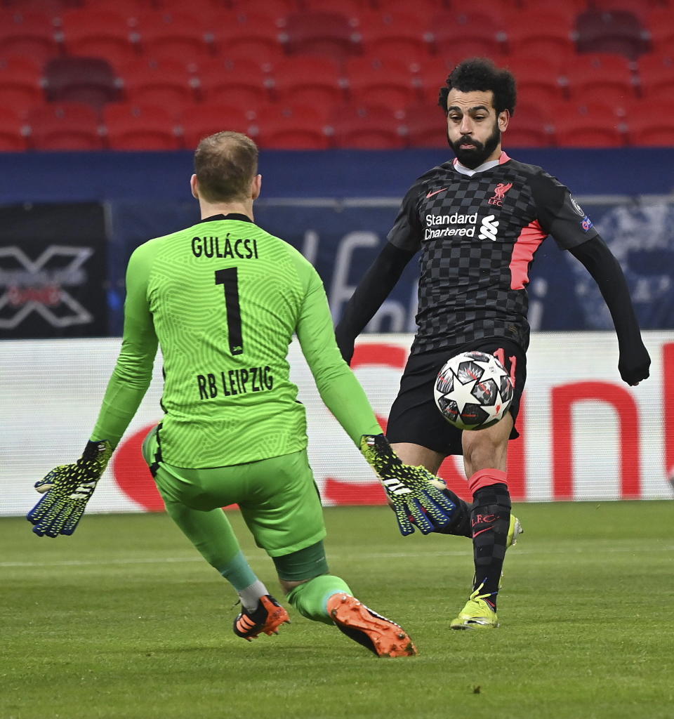 El arquero hungar del Leipzig Peter Gulacsi intenta contener el balón que controla Mohamed Salah del Liverpool en el encuentro de octavos de final de la Liga de Campeones en el Puskas Ferenc Arena en Budapest, Hungría el martes 16 de febrero del 2021. (Tibor Illyes/MTI via AP)