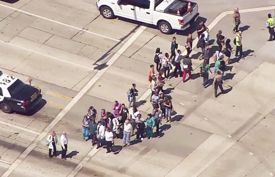 This photo from video provided by ABC7 Los Angeles shows people being evacuated from Kaiser Permanente Downey Medical Center, following reports of someone with a weapon at the facility in Downey, Calif., Tuesday, Sept. 11, 2018. Los Angeles County sheriff's officials say a suspect is in custody and deputies and police officers are methodically searching the complex. (ABC7 Los Angeles via AP)