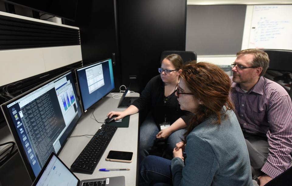 Carlotta Porzio, foreground, of the Lawrence Berkeley National Laboratory, works with fellow Lawrence Berkeley researcher Heather Crawford, left, as Sean Liddick, associate professor of chemistry and FRIB&#39;s director of experimental science looks on, Friday, May 6, 2022, at the Data U monitoring area at the Facility for Rare Isotope Beams at Michigan State University.