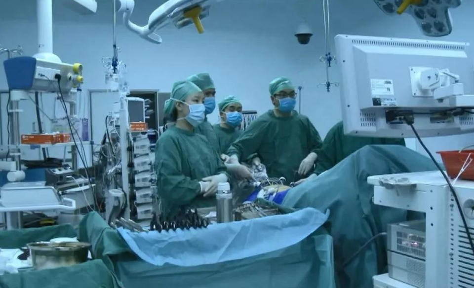 Doctor Zhou Yu with his colleagues (AsiaWire)  Social media users have heaped praise on a doctor who was pictured sleeping in an operating theatre after his colleagues revealed he was actually taking a nap after seven consecutive surgeries. 
