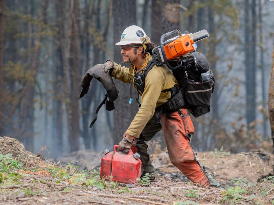 A Lakeview Hotshots firefighter carries equipment and fuel for containing the Cedar Creek fire near Oakridge, Ore., in 2022. <a href="https://www.gettyimages.com/detail/news-photo/hotshot-firefighter-works-to-contain-the-cedar-creek-fire-news-photo/1243179718" rel="nofollow noopener" target="_blank" data-ylk="slk:Dan Morrison / AFP via Getty Images;elm:context_link;itc:0;sec:content-canvas" class="link ">Dan Morrison / AFP via Getty Images</a>