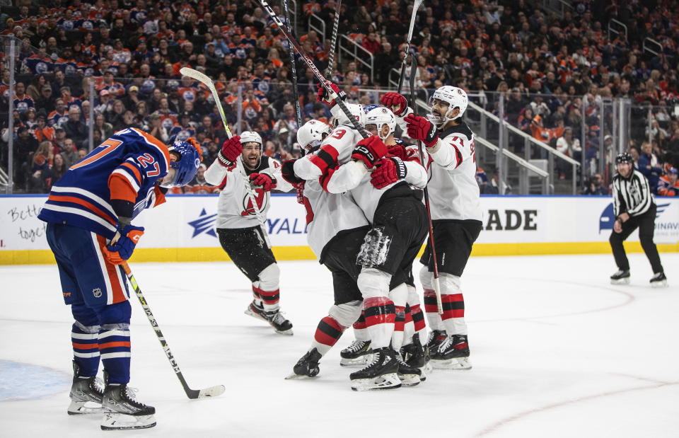 New Jersey Devils celebrate a goal as Edmonton Oilers' Brett Kulak (27) looks down during the third period of an NHL hockey game Thursday, Nov. 3, 2022, in Edmonton, Alberta. (Jason Franson/The Canadian Press via AP)