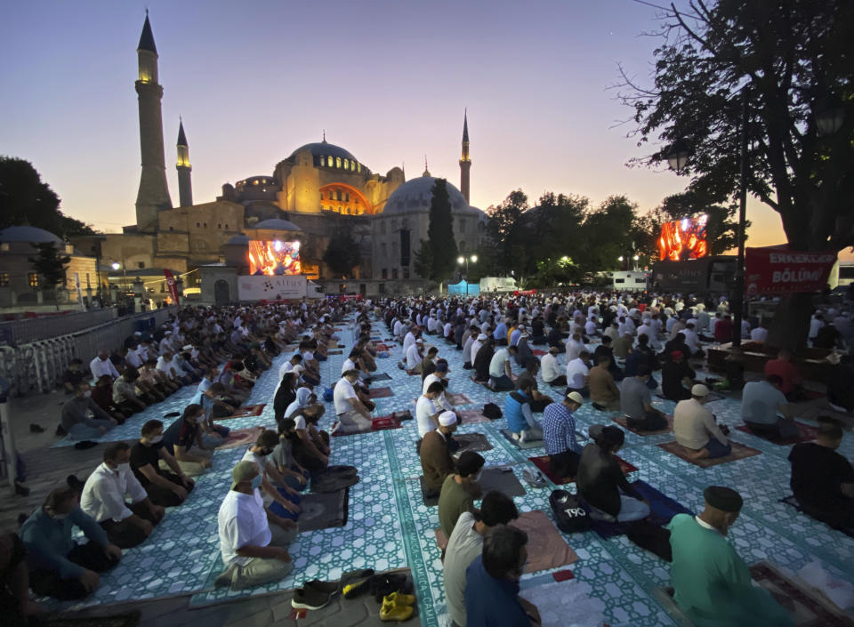 Muslims, wearing protective masks as a precaution against the coronavirus, offer their prayers during the Eid al-Adha prayer backdropped by the Byzantine-era Hagia Sophia, recently converted back to a mosque, in the historic Sultanahmet district of Istanbul, early Friday, July 31, 2020. Eid al-Adha, also known as the Festival of Sacrifice, at the end of the hajj pilgrimage to Mecca, is amajor holiday observed by billions of Muslims across the globe.This is the first Feast of Sacrifice since the onset of the global coronavirus pandemic. (AP Photo/Mehmet Guzel)