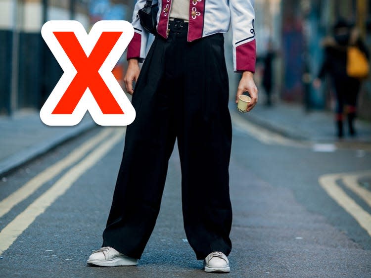 red x next to someone wearing a pair of black baggy pants with a statement jacket in the street