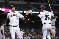 Arizona Diamondbacks' Carson Kelly (18) and Pavin Smith (26) celebrate after scoring on a double hit by David Peralta during the fifth inning of a baseball game against the Miami Marlins, Tuesday, May 11, 2021, in Phoenix. (AP Photo/Matt York)