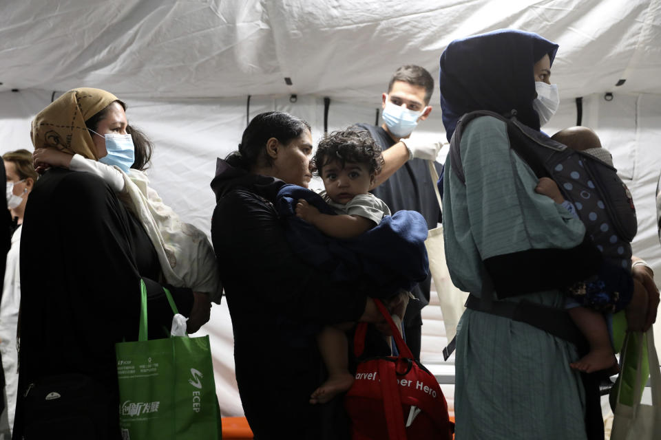 Evacuated citizens from Afghanistan arrive at Tirana International Airport in Tirana, Albania, Friday, Aug. 27, 2021. A government decision has planned that the Afghans may stay at least a year during which they will proceed with their application for special visas before they move on to the U.S. for final settlement. (AP Photo/Franc Zhurda)