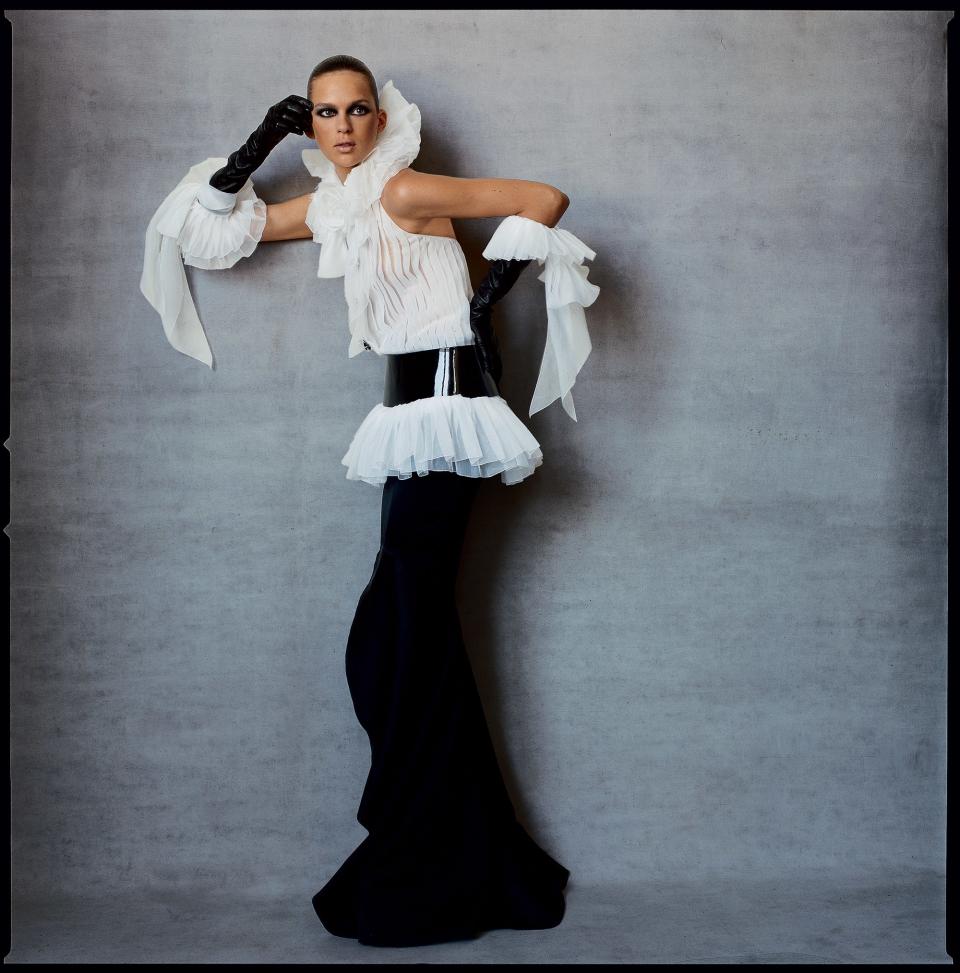 Elise Crombez in a Chanel Haute Couture organza top with jeweled buttons, floor-skimming fishtail skirt, wide patent belt, and leather gloves with snowy organza bows.