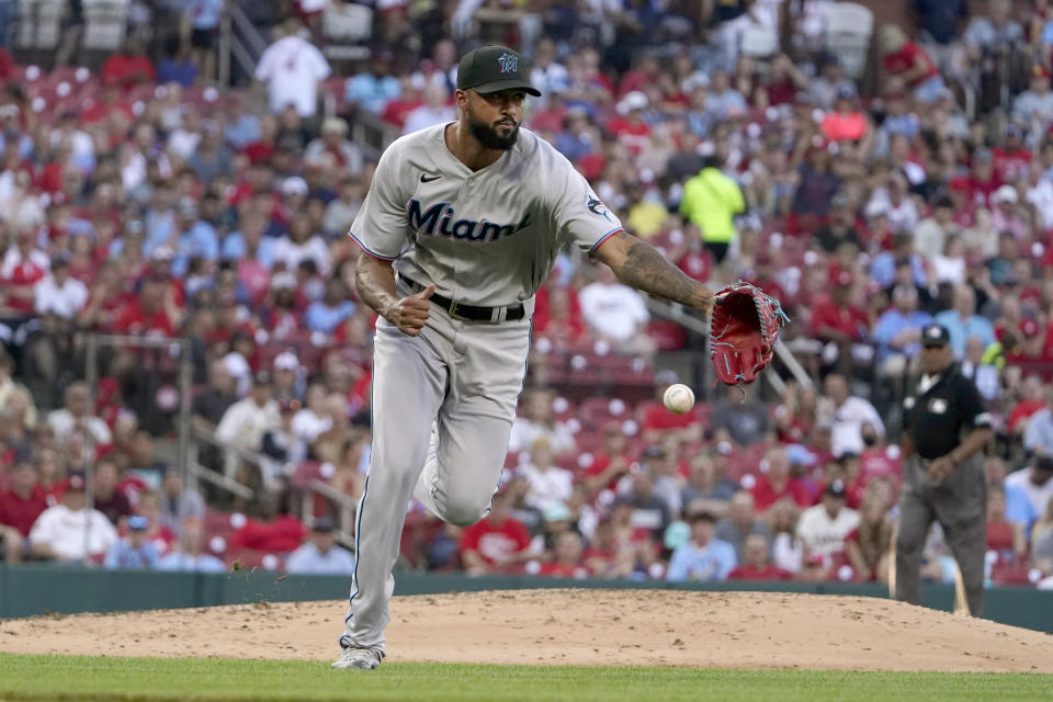 Miami Marlins starting pitcher Sandy Alcantara reaches for a ball hit by St. Louis Cardinals' Brendan Donovan during the third inning of a baseball game Wednesday, June 29, 2022, in St. Louis. Donovan was able to reach base on a throwing error by Marlins first baseman Garrett Cooper on the play. (AP Photo/Jeff Roberson)