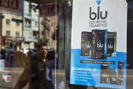 A man walks past an advertisement for e-cigarettes in New York April 24, 2014. REUTERS/Lucas Jackson