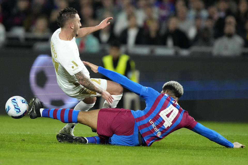 A-Leagues All Stars' Reno Piscopo, left, is tackled by Barcelona's Ronald Araujo during their friendly soccer match in Sydney, Australia, Wednesday, May 25, 2022. (AP Photo/Rick Rycroft)