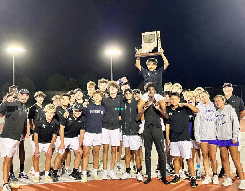 Bloomington South boys tennis team celebrates winning the regional title with Caleb Lian holding the trophy after this three-set win clinched the title on Wednesday, Oct. 9, 2024.