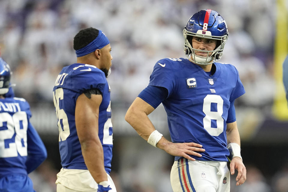 New York Giants quarterback Daniel Jones (8) talks with teammate running back Saquon Barkley, left, during the second half of an NFL football game against the Minnesota Vikings, Saturday, Dec. 24, 2022, in Minneapolis. (AP Photo/Abbie Parr)