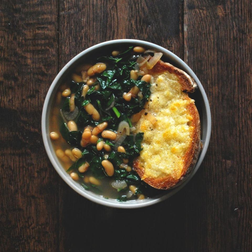 large piece of toasted and cheesy bread in the bowl of soup