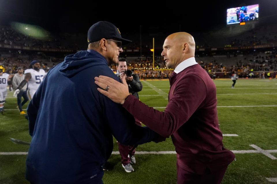 Michigan head coach Jim Harbaugh, left, and Minnesota head coach P. J. Fleck, right, shake hands following Michigan's 52-10 win over Minnesota on Saturday, Oct. 7, 2023, in Minneapolis.