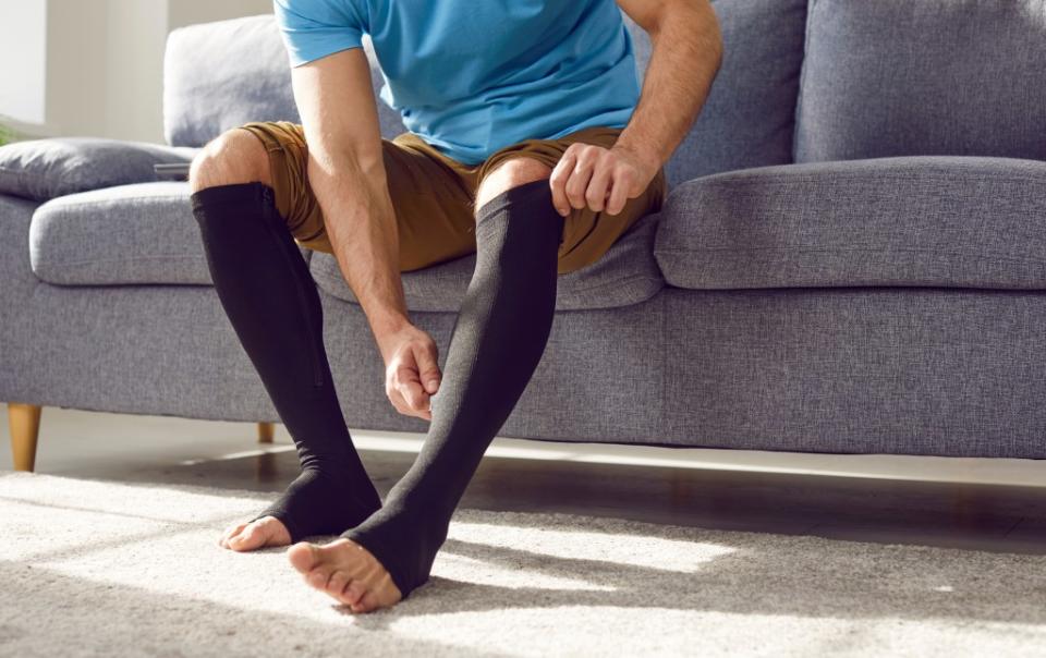Compression socks gently apply pressure to ankles and legs, which can help improve blood flow, reduce swelling and pain and prevent blood clots. Studio Romantic – stock.adobe.com