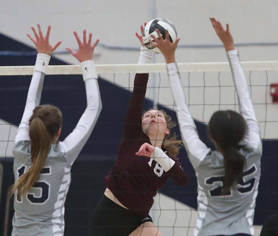 Catherine Clemens, center, of Walsh Jesuit hits ball over for a point past Genevieve Talentino, left, of Twinsburg and Jordyn Fears during the second set of their Division I volleyball district semifinal match at Solon High School in Solon on Tuesday night. 