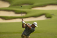 Bryson Dechambeau hits from the fairway on the ninth hole during a practice round for the PGA Championship golf tournament, Tuesday, May 17, 2022, in Tulsa, Okla. (AP Photo/Matt York)