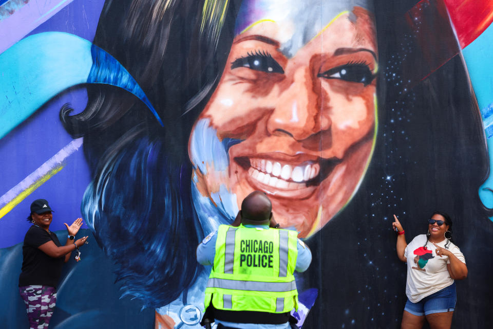 TOPSHOT - Un policía de Chicago toma una fotografía de personas posando ante un mural de la candidata presidencial demócrata a la vicepresidenta de Estados Unidos, Kamala Harris, afuera del United Center antes de la Convención Nacional Demócrata (DNC) en Chicago, Illinois, el 17 de agosto de 2024. El mural, creado por Ian Robertson y Salt and Pique Brown, fue encargado por Emily's List en 2020. La vicepresidenta Kamala Harris aceptará formalmente la nominación del partido a la presidencia en la DNC que se llevará a cabo del 19 al 22 de agosto en Chicago. (Foto de Charly TRIBALLEAU / AFP) (Foto de CHARLY TRIBALLEAU/AFP vía Getty Images)