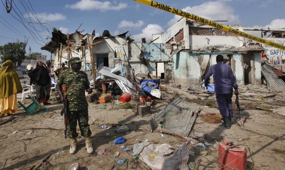 An African Union soldier stands in front of destroyed shops near the scene of a suicide car bomb attack on a police station adjacent to the seaport in the capital Mogadishu, Somalia Sunday, Dec. 11, 2016. The suicide car bomber killed a number of people, and Islamic extremist rebels al-Shabab claimed responsibility for the attack. (AP Photo/Farah Abdi Warsameh)