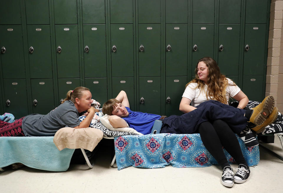 Vickie Grate, left, waits in a shelter with her son Chris, center, and his girlfriend Sarah, who only gave their first names, for Hurricane Florence to pass after evacuating from their nearby homes, in Conway, S.C., Wednesday, Sept. 12, 2018. (AP Photo/David Goldman)