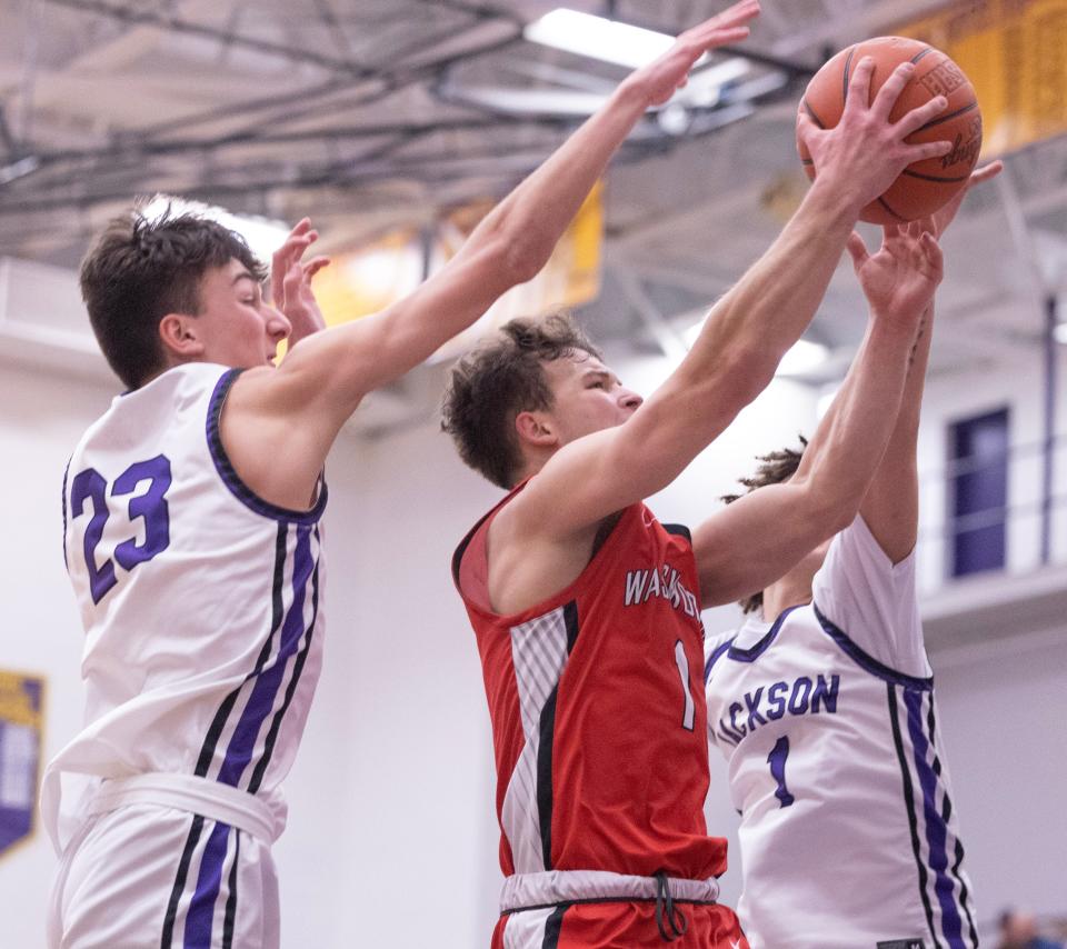 Jackson's Landon Thiel (left) and Cameron Weekley defend Wadsworth's Maxx Bosley in the second half at Jackson Tuesday, Feb.13, 2024. Thiel and Bosley's fathers were teammates in high school at Jackson.