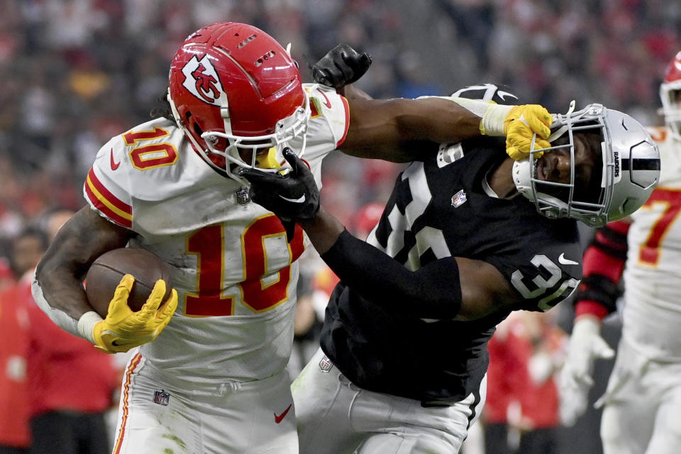 Kansas City Chiefs running back Isiah Pacheco (10) struggles for yardage as Las Vegas Raiders safety Duron Harmon (30) defends during the second half of an NFL football game Saturday, Jan. 7, 2023, in Las Vegas. (AP Photo/David Becker)